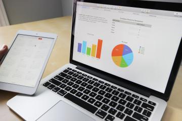 Gray and black laptop computer displaying charts.